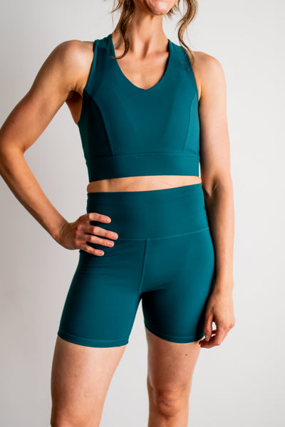 Person wearing a teal athletic outfit on a plain background