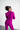 Person wearing a bright purple outfit against a white background