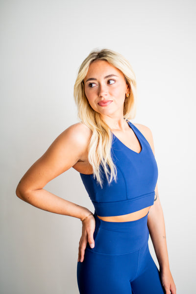 Woman wearing a blue athletic outfit against a plain background