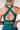 Person wearing a teal sports bra and leggings with a plain background