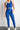 Person wearing a blue bra and leggings with a white background