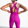 Person wearing a bright purple athletic outfit with a white background