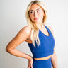 Woman wearing a blue athletic outfit against a plain background