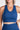 Person wearing a blue sports bra and leggings on a white background